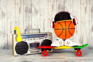 Müzik Hip hop tarzı ve spor kavram. Kulaklıklar, modaya uygun kap, spor ayakkabı, basketbol topu, kaykay ile Vintage ses çalar.