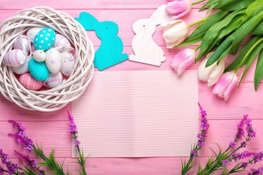 Paskalya yumurtaları bir hasır sepet ve Lale pembe bir arka plan üzerinde bir buket. Paskalya için tatil tebrik kartı!