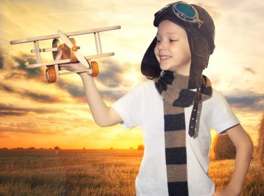 Gün batımında doğada yaz aylarında seyahat uçak hayalleri ile çocuk pilot pilot