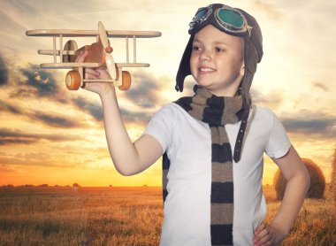 Gün batımında doğada yaz aylarında seyahat uçak hayalleri ile çocuk pilot pilot