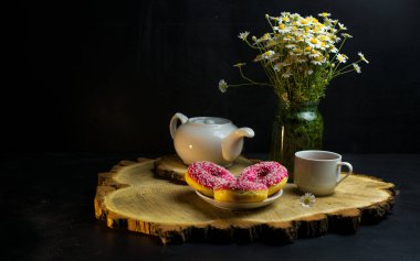  Kahvaltı. Bir fincan papatya çayı ve taze lezzetli çörekler. Bir buket güzel papatya..