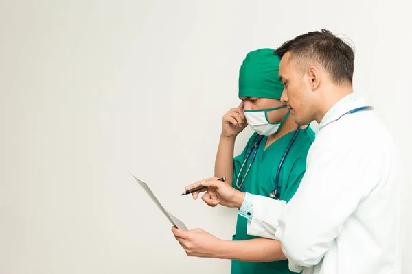 Médicos masculinos asiáticos con película de rayos X sobre fondo blanco — Foto de Stock