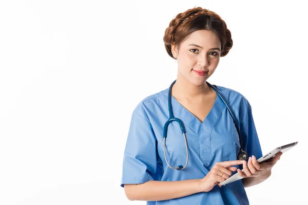 Kvinnliga Asiatiska sjuksköterska med hjälp av en digital tablett & klädd i en blå kappa — Stockfoto