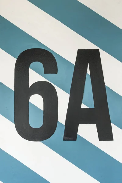 Number six on the concrete wall in car park space with blue and — Stock Photo, Image
