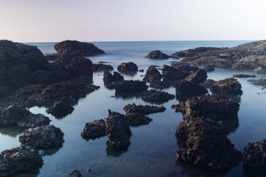 Güzel manzara günbatımı taşlarla denizde uzun kayalar 
