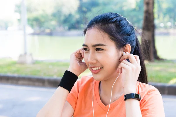 Young beautiful attracttive Asian female runner listening to mus — Stock Photo, Image