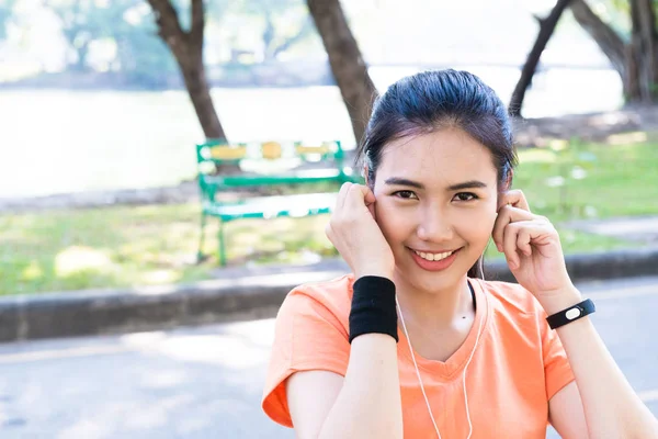 Young beautiful attracttive Asian female runner listening to mus — Stock Photo, Image