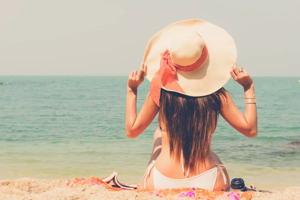 Schöne asiatische Bikini-Frau sitzt am Strand Blick ins Meer — Stockfoto