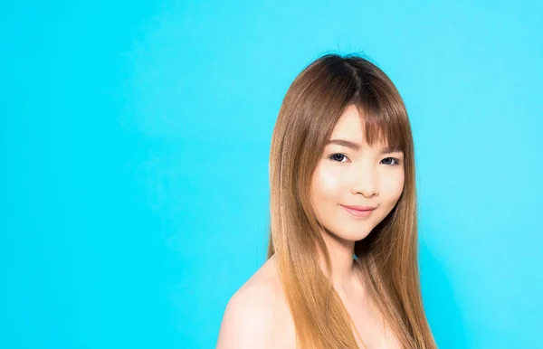 Ung asiatisk kvinna med lyckligt leende isolerad på blå bakgrund. — Stockfoto