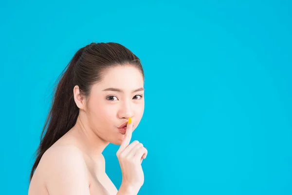Junge asiatische Frau mit geheimem Schweigen posiert isoliert auf blauem Rücken — Stockfoto