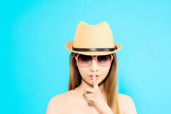 Jeune femme asiatique avec pose secrète de silence isolé sur fond bleu — Photo