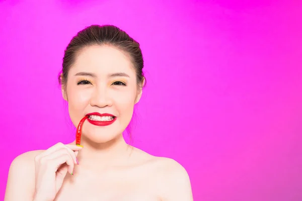 Joven mujer asiática mordiendo chile aislado en fondo rosa . — Foto de Stock