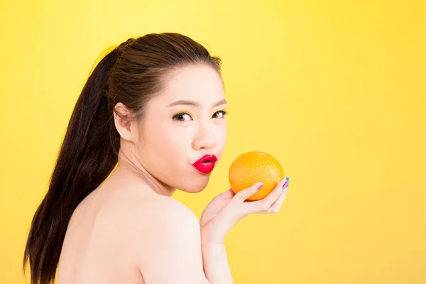 Giovane donna asiatica baciare arancio isolato in fondo giallo . — Foto Stock
