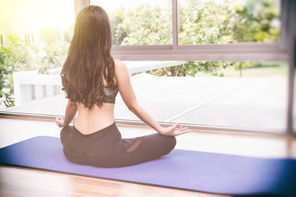 Vacker ung vältränad asiatisk kvinna gör yoga. — Stockfoto