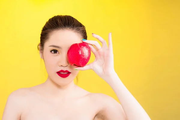 Joven asiática sosteniendo manzana aislada en fondo amarillo — Foto de Stock