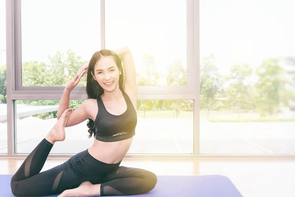 Beautiful young fit asian woman doing yoga.