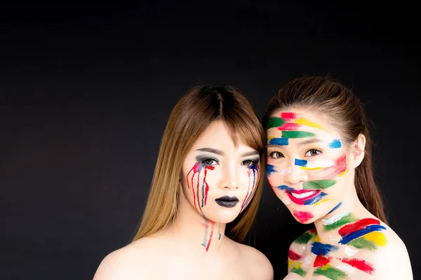 Two Asian women portrait isolated on black background with abstr