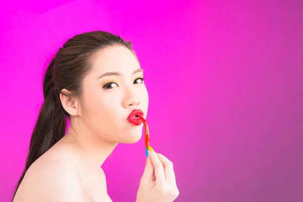 Joven asiática besándose chili aislado en rosa fondo . — Foto de Stock