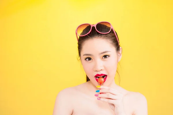 Jeune femme asiatique baisers sucette isolé sur fond jaune — Photo