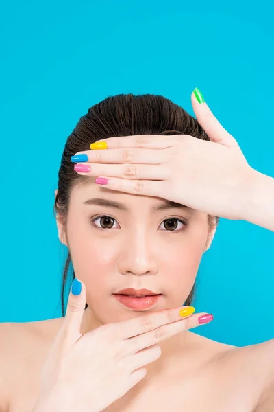 Junge asiatische Frau mit der Hand im Gesicht isoliert auf blauem Hintergrund. — Stockfoto