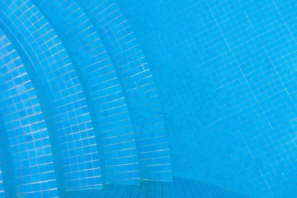 Wasser auf blau gefliestem Schwimmbad mit Treppe Hintergrund. — Stockfoto