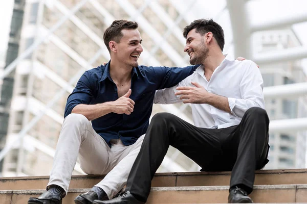 Deux hommes d'affaires heureux assis sur des escaliers en béton secouant ha — Photo