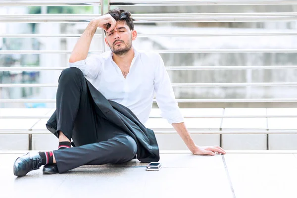 Müder Geschäftsmann sitzt auf dem Boden. — Stockfoto