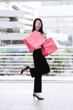 Kentsel şehir kavramı shopper modern tek kadın. Holding Kağıt çanta portre duygu alışveriş kırmızı mutlu büyük şehirde alışveriş gülümseyen Modern yeni zengin genç Asya kadın. Arka planda Road alışveriş ile.