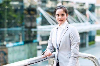 Kendine güvenen iş kadın portresi. Emin seyir dışında duran genç profesyonel kariyer iş kadın. Doğal ışık ile açık alınan. Genç kadın liderlik için kariyer yolu kavramı.