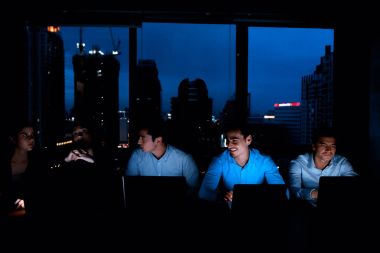 Aydınlık ile gece geç saatlerde bir motivasyonu yüksek iş ekibi