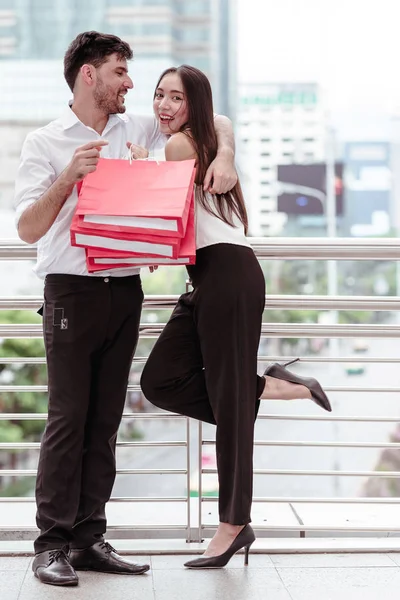 Happy couple cheering after a hard day of huge sale shopping in — Stock Photo, Image