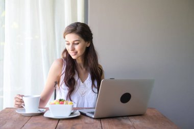 Kahve içer ve dışında çalışan kadın. Dizüstü bilgisayarda onu tatil sırasında bir tropikal çalışan. Beyaz beyaz elbise ile kadın. Çevik. modile ofis kavramı.