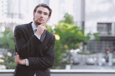 Kendine güvenen genç iş adamı siyah kravat portre. Siyah takım elbise ve kravat, kızıl saç ve sakal doğal ışık, kendine güvenen iş adam kavramı ile açık alınan yakışıklı beyaz erkek.