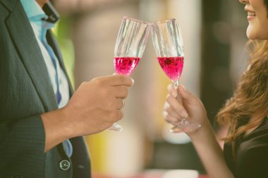 Erkek ve kadın parti kadeh birlikte yaptığı, tezahürat yakın çekim. Beyaz adam ve güzel tek Çinli kadın birlikte içinde toasting hava pub açın. Parti konsept.