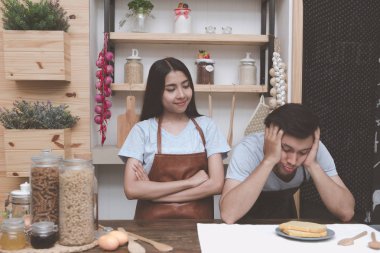 Genç Beyaz adam mutfakta Çinli kız arkadaşıyla yemek pişirmek için ne hakkında düşünmeye çalışıyorum. Marrige kavramı önce birlikte yaşayan genç Çift.