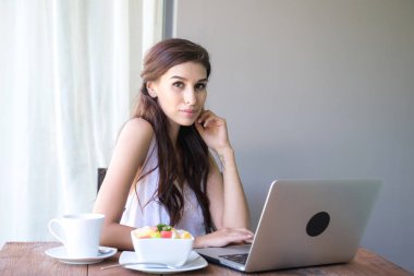 Kahve içer ve dışında çalışan kadın. Dizüstü bilgisayarda onu tatil sırasında bir tropikal çalışan. Beyaz beyaz elbise ile kadın. Çevik. modile ofis kavramı.