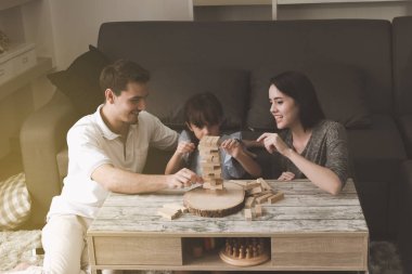 Annem ve babam oynamak puzzle oyunu oturma odasında kendi kızı ile birlikte. Aile eğlenceli zaman kavramı.