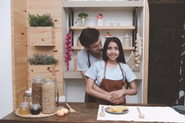 Genç adam mutfakta birbirlerine sarılma Çinli kız arkadaşıyla beyaz. Marrige kavramı önce birlikte yaşayan genç Çift.