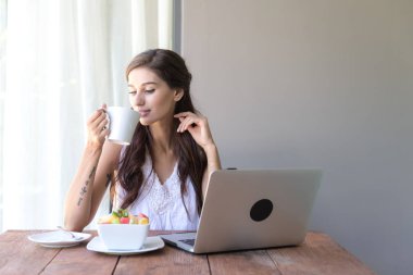 Kahve içer ve dışında çalışan kadın. Dizüstü bilgisayarda onu tatil sırasında bir tropikal çalışan. Beyaz beyaz elbise ile kadın. Çevik. modile ofis kavramı.