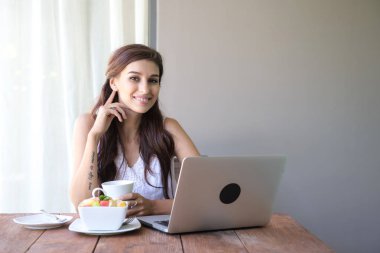 Kahve içer ve dışında çalışan kadın. Dizüstü bilgisayarda onu tatil sırasında bir tropikal çalışan. Beyaz beyaz elbise ile kadın. Çevik. modile ofis kavramı.