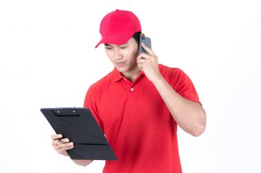 Genç lojistik kariyer kavramı. Mutlu teslim telefon ve onun teslim sipariş de arıyor. Beyaz arka plan üzerinde izole. Onun erken yirmili kırmızı şapkalı adam kırmızı polo tişört ve kot Asya Çin uygun.