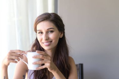 Kahve ve gülümseme sahip bir kadın. Güzel beyaz kadın onu sabah kahve sahip ve çok mutlu görünüyordu gülümseme.