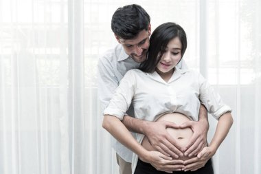 Karışık yarış ebeveynlik kavramı. Genç Çince hamile ve her diğer holding beyaz erkek kocası portresi. Gerçek altı aylık hamile kadın ile kapalı alınan.