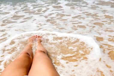 Güzel genç tek beyaz kadın plajda. mutlu rahatlatıcı aşağı beyaz bikini giyen döşeme. POV stili.