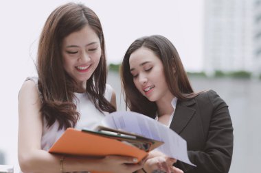 İki güzel kendine güvenen Asya iş stajyer kadın birbirine alarak. Office mola sırasında doğal ışık açık alınan office uymak iki kadınlar. Kadın kariyer kavramı.