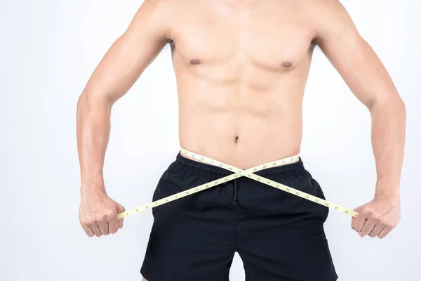 フィットネスと健康の概念 フィット スポーツ男は 白い背景で隔離 彼の体脂肪の量を確認する腰を測定します 半分裸のアジア中国リーン筋肉男性着て黒ショーツ — ストック写真