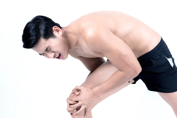 健身和健康的概念 适合运动男子膝伤 孤立在工作室的白色背景 半裸亚裔中国瘦肌肉男穿着黑色短裤 — 图库照片