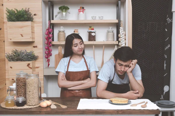 Genç Beyaz adam mutfakta Çinli kız arkadaşıyla yemek pişirmek için ne hakkında düşünmeye çalışıyorum. Marrige kavramı önce birlikte yaşayan genç Çift.