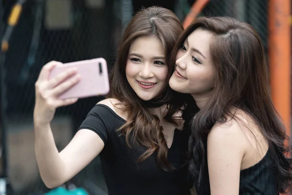 傍晚时分 两个朋友一起在酒馆里自拍 两位美丽的中国女子在向社交媒体摆姿势前带着性感的姿势自拍 党和在线的存在概念 — 图库照片