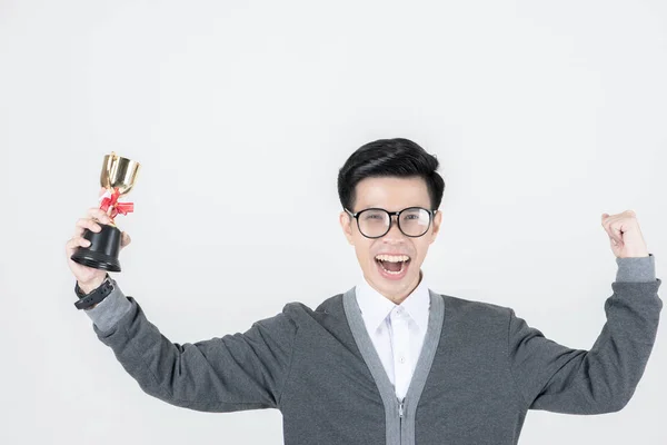 オタク男が大勝利します 若いアジアのオタク男 トロフィーを持って 笑みを浮かべて立っている白い背景に分離しながら勝利のポーズ — ストック写真